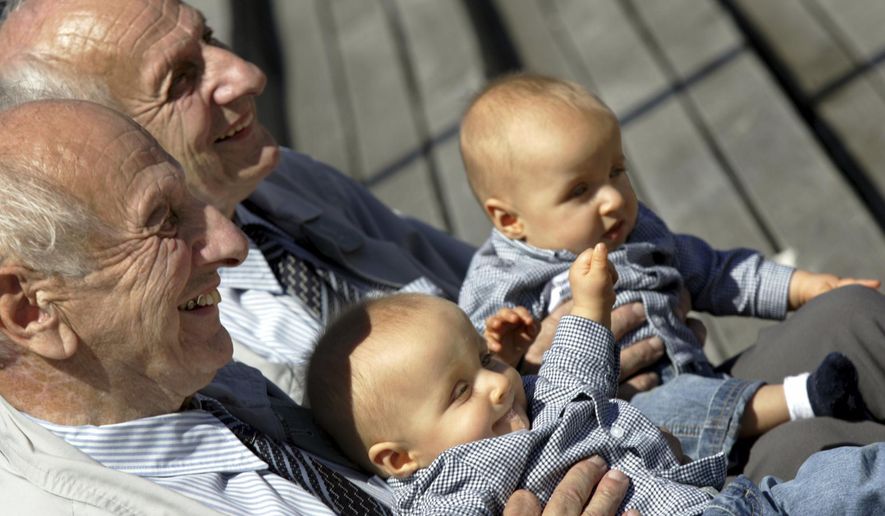 FILE - In this Saturday, June 18, 2005 file photo, identical twins Alf, left, and Sven Fehnhanhn, left background, 79, from Kassel, pose along with seven-month-old Luis Carl, right, und Albert Frank Millgramm, right background, during a twins' meeting in Berlin. According to research published on Thursday, Jan. 7, 2021, identical twins are not exactly genetically the same. (AP Photo/Jockel Finck)