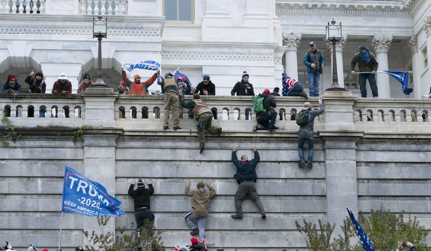 In this Jan. 6, 2021, file photo, supporters of President Donald Trump climb the west wall of the the U.S. Capitol in Washington. (AP Photo/Jose Luis Magana File)