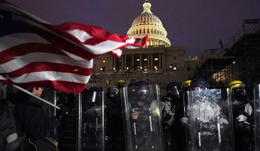 Police stand guard after a day of riots at the U.S. Capitol in Washington on Wednesday, Jan. 6, 2021. (AP Photo/Julio Cortez)