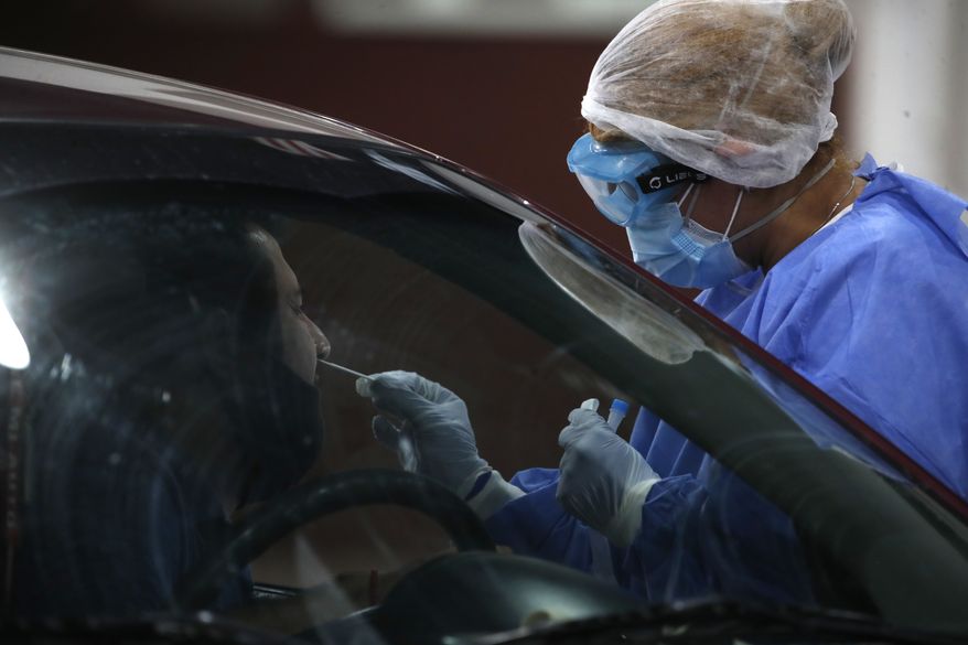 In this file photo, a healthcare worker takes a nasal swab sample to test for COVID-19, in Buenos Aires, Argentina, Friday, Jan. 8, 2021. (AP Photo/Natacha Pisarenko) **FILE**