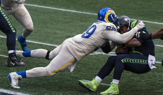 FILE - Los Angeles Rams defensive lineman Aaron Donald sacks Seattle Seahawks quarterback Russell Wilson during the second half of an NFL football game in Seattle, in this Sunday, Dec. 27, 2020, file photo. Donald was selected Friday, Jan. 8, 2021, to The Associated Press All-Pro Team. (AP Photo/Stephen Brashear, File)