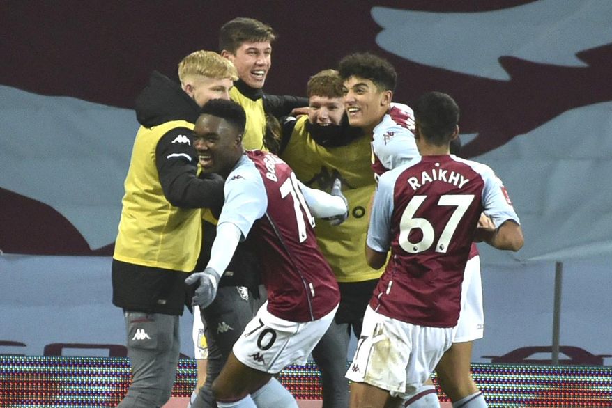 Aston Villa's players celebrate a goal by Aston Villa's Louie Barry during the FA Cup 3rd round soccer match between Aston Villa and Liverpool at Villa Park stadium in Birmingham, England, Friday, Jan. 8, 2021. (AP Photo/Rui Vieira)