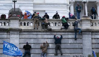 Supporters of President Donald Trump climb the West wall of the the U.S. Capitol on Wednesday, Jan. 6, 2021, in Washington. (AP Photo/Jose Luis Magana)