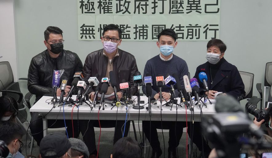 Former Democratic Party legislators Andrew Wan, left, Lam Cheuk-ting, second left, and Helena Wong, right, attend a press conference after being released on bail in Hong Kong, Friday, Jan. 8, 2021. Some former Hong Kong legislators and pro-democracy activists were released on bail late Thursday, after being arrested under Hong Kong's national security law as part of Wednesday's mass arrests of 53 people. The Chinese in the background reads "Totalitarian government suppresses dissidents, fearless of indiscriminate arrest, we walk forward together." (AP Photo/Kin Cheung)