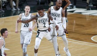 Michigan State&#39;s Joshua Langford, right, and Rocket Watts (2) celebrate along with Joey Hauser (20) and Foster Loyer, left, during the first half of the team&#39;s NCAA college basketball game against Purdue on Friday, Jan. 8, 2021, in East Lansing, Mich. (AP Photo/Al Goldis)