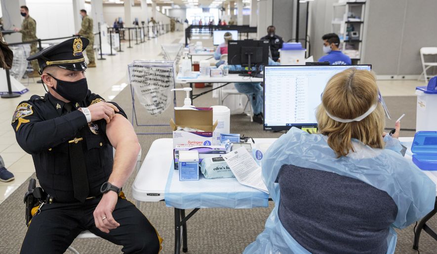 Sergeant Michael Zarro, of the Mount Olive, NJ, Police Department, rolls up his sleeve to receive a COVID-19 vaccination at the Morris County, vaccination site, in Rockaway, NJ, Friday, Jan. 8, 2021. Gov. Phil Murphy toured what's being called a vaccine megasite at a former Sears store in Morris County on Friday where health officials hope to vaccinate more than 2,000 people per day in coming weeks and months. (Sarah Blesener/The New York Times via AP, Pool)