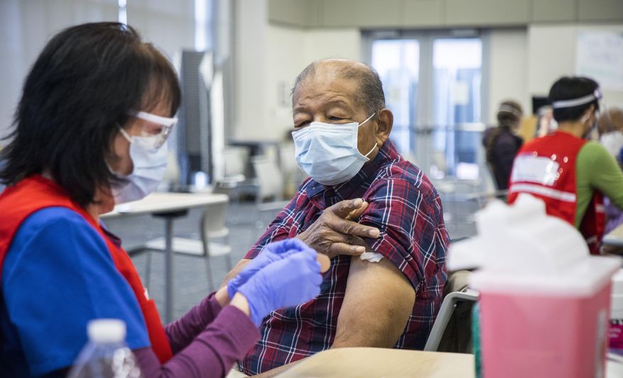 Dr. John W. Hatch waits for a bandage after receiving the Moderna COVID-19 vaccine from registered nurse Lorraine Honeywell at the Durham County Department of Public Health in Durham, N.C., on Friday, Jan. 8, 2021. (Julia Wall/The News & Observer via AP)