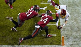 Washington Football Team quarterback Taylor Heinicke (4) dives towards the end zone to score a touchdown against Tampa Bay Buccaneers inside linebackers Kevin Minter (51) and Lavonte David (54) during the second half of an NFL wild-card playoff football game, Saturday, Jan. 9, 2021, in Landover, Md. (AP Photo/Al Drago)