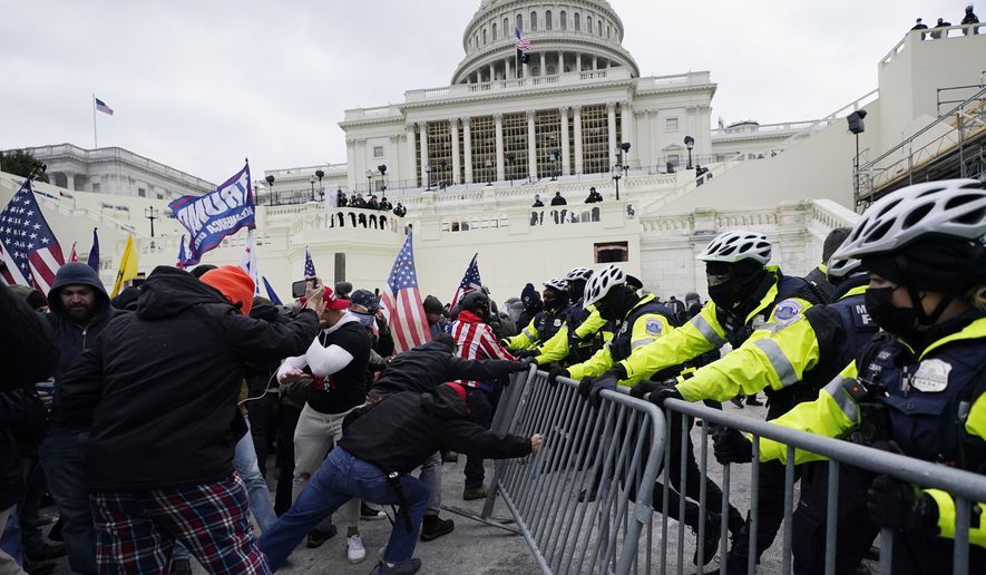 Trump supporters try to break through a police barrier, Wednesday, Jan. 6, 2021, at the Capitol in Washington. As Congress prepares to affirm President-elect Joe Biden&#39;s victory, thousands of people have gathered to show their support for President Donald Trump and his claims of election fraud. (AP Photo/Julio Cortez)