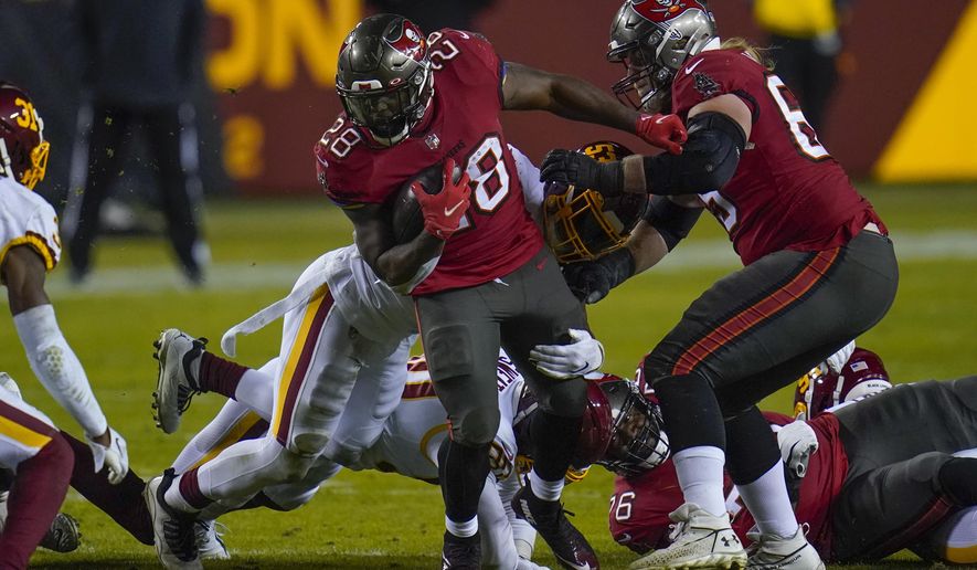 Tampa Bay Buccaneers running back Leonard Fournette (28) is taken down by Washington Football Team middle linebacker Jon Bostic (53) during the first half of an NFL wild-card playoff football game, Saturday, Jan. 9, 2021, in Landover, Md. (AP Photo/Julio Cortez)