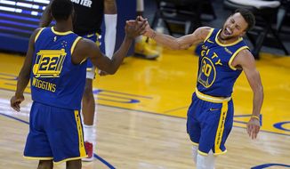 Golden State Warriors forward Andrew Wiggins (22) celebrates with guard Stephen Curry (30) after Wiggins made a 3-point shot against the Los Angeles Clippers during the second half of an NBA basketball game in San Francisco, Friday, Jan. 8, 2021. (AP Photo/Tony Avelar)