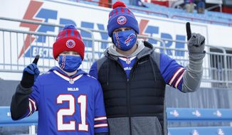 Buffalo Bills fans Scott Hammond, right, and his son Landon pose for a photograph as their team warms up before an NFL wild-card playoff football game against the Indianapolis Colts, Saturday, Jan. 9, 2021, in Orchard Park, N.Y. The Hammonds were among the lucky 6,700 few to land tickets for the Bills wild-card playoff against the Indianapolis Colts for Buffalo&#39;s first home playoff game in 24 years. (AP Photo/Jeffrey T. Barnes)