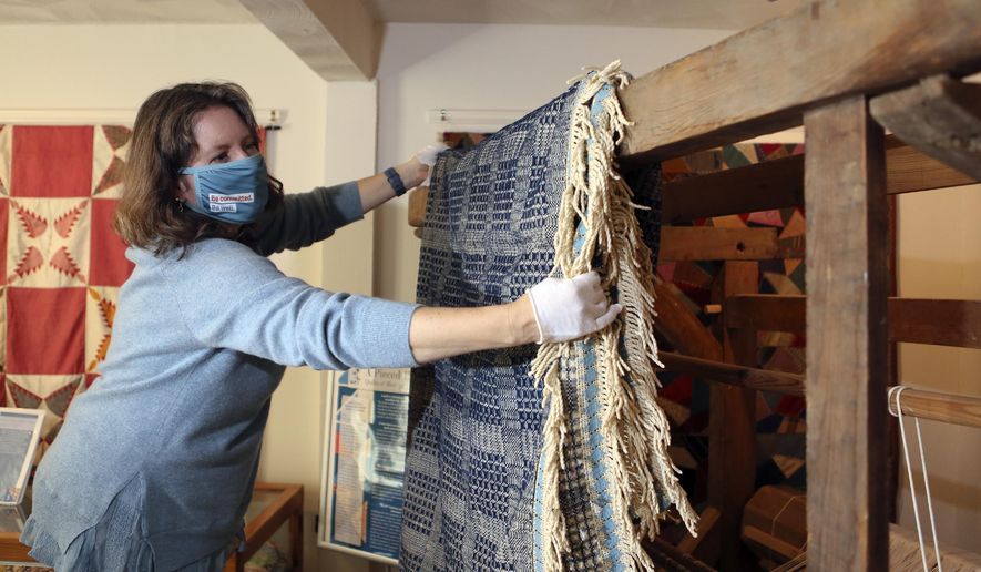 Montgomery Museum of Art &amp;amp; History Curator Sherry Wyatt drapes the slave made coverlet on a period loom, Tuesday, Dec. 15, 2020, in Christiansburg Va. Although enslaved people worked in every aspect of the textile industry in antebellum America, individual pieces made by them are rarely verified and very few exist in museum collections today. (Matt Gentry/The Roanoke Times via AP)