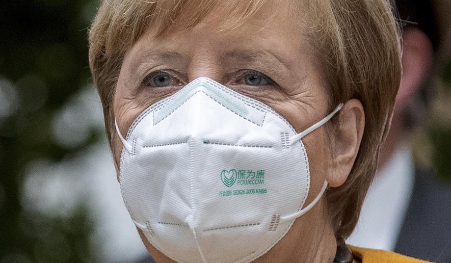 File - File picture taken Nov.2, 2020 shows German Chancellor Angela Merkel arriving for a press conference in Berlin, Germany. The coronavirus pandemic is colliding with politics as Germany embarks on its vaccination drive and one of the most unpredictable election years in its post-World War II history. (AP Photo/Michael Sohn, file)