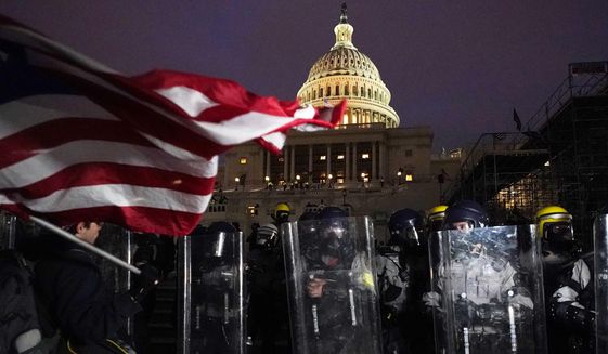 Police stand guard after a day of riots at the U.S. Capitol in Washington on Wednesday, Jan. 6, 2021. (AP Photo/Julio Cortez)