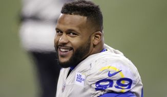 Los Angeles Rams defensive end Aaron Donald smiles as he stands on the sideline late in the second half of an NFL wild-card playoff football game against the Seattle Seahawks, Saturday, Jan. 9, 2021, in Seattle. (AP Photo/Scott Eklund)