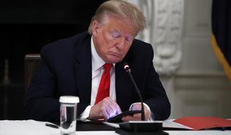 In this Thursday, June 18, 2020, photo, President Donald Trump looks at his phone during a roundtable with governors on the reopening of America&#39;s small businesses, in the State Dining Room of the White House in Washington. (AP Photo/Alex Brandon) **FILE**