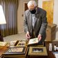Recently retired Wyoming U.S. Sen. Mike Enzi sorts through photographs in his new Gillette, Wyoming, office on Tuesday, Dec. 22, 2020. (Mike Moore/Gillette News Record via AP)