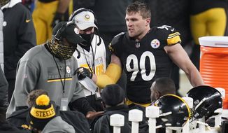 Pittsburgh Steelers head coach Mike Tomlin, left, talks with his defense, including outside linebacker T.J. Watt (90), during the second half of an NFL wild-card playoff football game against the Cleveland Browns, Sunday, Jan. 10, 2021, in Pittsburgh. (AP Photo/Keith Srakocic)