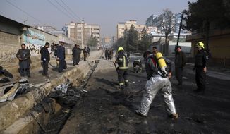 Afghan firefighters work at the site of a bombingh attack in Kabul, Afghanistan, Sunday, Jan. 10, 2021. A roadside bomb exploded in Afghanistan&#39;s capital Sunday, killing at least a few people in a vehicle, the latest attack to take place even as government negotiators are in Qatar to resume peace talks with the Taliban. (AP Photo/Rahmat Gul)