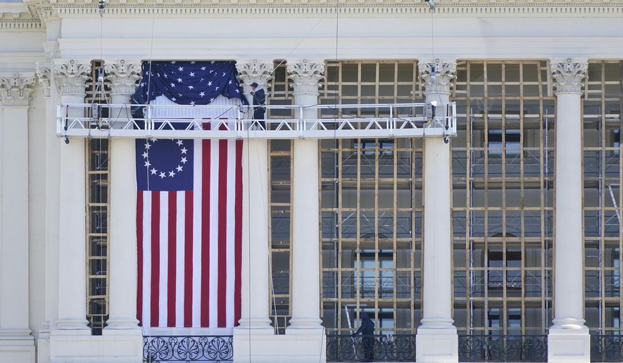 Workers install a flag on the West Front of the U.S. Capitol as preparations take place for President-elect Joe Biden's inauguration, Saturday, Jan. 9, 2021, in Washington. (AP Photo/Patrick Semansky)