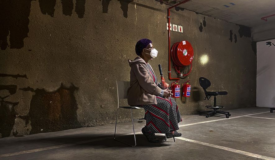 A lone woman waits to be tested for COVID-19 in the parking garage of a shopping mall in Johannesburg, South Africa, Monday Jan. 11, 2021. South Africa is struggling to cope with a spike in COVID-19 cases that has already overwhelmed some hospitals, as people returning from widespread holiday travel speed the country&#39;s more infectious coronavirus variant. (AP Photo/Jerome Delay)