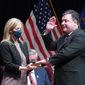 Todd Rokita is sworn in as Indiana&#39;s attorney general by Chief Justice Loretta H. Rush on a bible held by his wife, Kathy, during an inaugural ceremony at the Indiana State Museum, Monday, Jan. 11, 2021, in Indianapolis. (AP Photo/Darron Cummings)