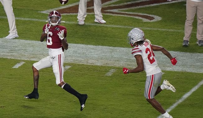 Alabama wide receiver DeVonta Smith catches a touchdown pass in front of Ohio State cornerback Shaun Wade during the first half of an NCAA College Football Playoff national championship game, Monday, Jan. 11, 2021, in Miami Gardens, Fla. (AP Photo/Wilfredo Lee)