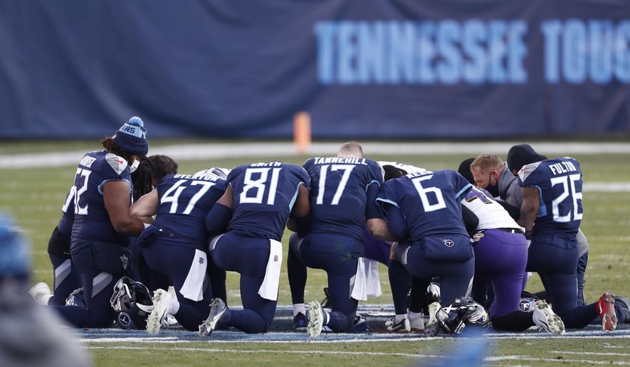 Tennessee Titans players pray on the field after losing to the Baltimore Ravens in an NFL wild-card playoff football game Sunday, Jan. 10, 2021, in Nashville, Tenn. The Ravens won 20-13. (AP Photo/Wade Payne)