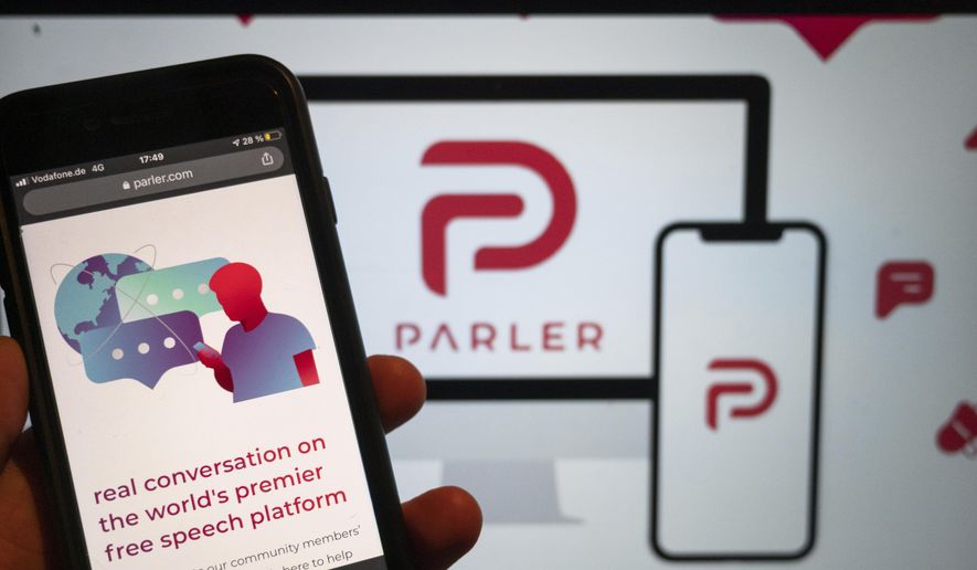 The website of the social media platform Parler is displayed in Berlin, Jan. 10, 2021. The platform&#39;s logo is on a screen in the background. The conservative-friendly social network Parler was booted off the internet Monday, Jan. 11, over ties to last week&#39;s siege on the U.S. Capitol, but not before hackers made off with an archive of its posts, including any that might have helped organize or document the riot. (Christophe Gateau/dpa via AP)