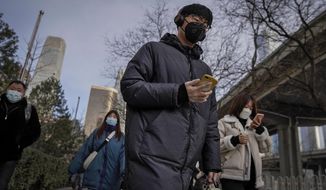 A man wearing a face mask and a disposable gloves to help curb the spread of the coronavirus heads to work with other masked people during the morning rush hour in Beijing, Monday, Jan. 11, 2012. Chinese health authorities say scores more people have tested positive for coronavirus in Hebei province bordering on the capital Beijing. The outbreak focused on the Hebei cities of Shijiazhuang and Xingtai is one of China&#39;s most serious in recent months and comes amid measures to curb the further spread during next month&#39;s Lunar New Year holiday. (AP Photo/Andy Wong)