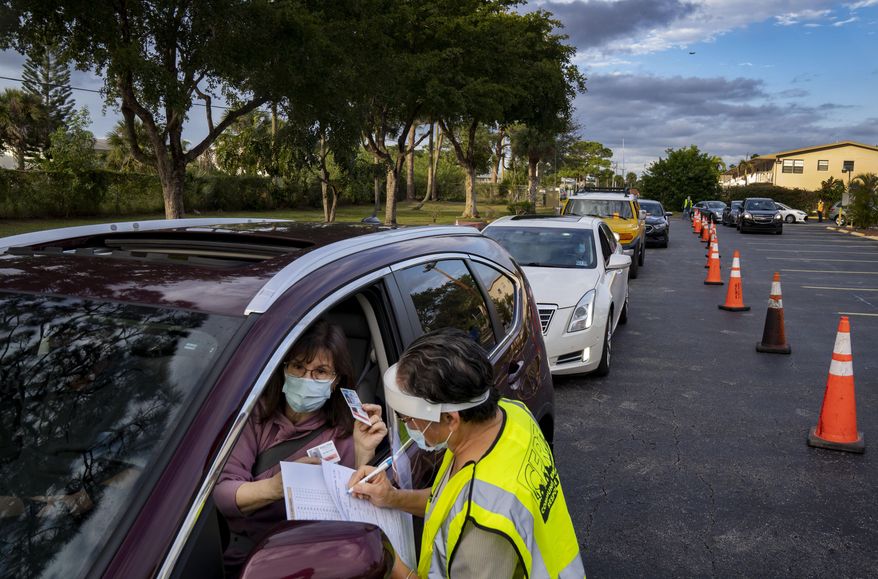 Century Village resident Maria Cole shows identification to make an appointment for the COVID-19 vaccine in West Palm Beach, Fla., on Monday, Jan. 11, 2021. The community will receive 3,000 doses to use starting on Wednesday. (Greg Lovett/The Palm Beach Post via AP)