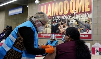 A health care worker administers a COVID-19 vaccination at the new Alamodome COVID-19 vaccine site, Monday, Jan. 11, 2021, in San Antonio, Texas. Officials say the site is providing 1,500 vaccinations per day. (AP Photo/Eric Gay)