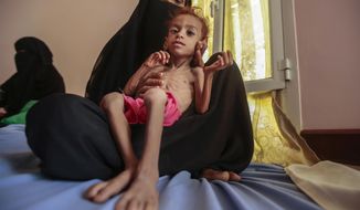 FILE - In this Oct. 1, 2018, file photo, a woman holds a malnourished boy at the Aslam Health Center, in Hajjah, Yemen. A leading aid organization on Monday warned that U.S. Secretary of State Mike Pompeo&#x27;s move to designate Yemen’s Iran-backed Houthi rebels as a “foreign terrorist organization” would deal another “devastating blow&amp;quot; to the impoverished and war-torn nation. (AP Photo/Hani Mohammed, File)