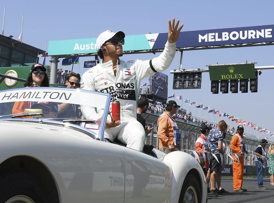 In this March 17, 2019, file photo, Mercedes driver Lewis Hamilton of Britain waves as the drivers parade begins ahead of the Australian Grand Prix in Melbourne, Australia. The start of the 2021 Formula One season has been delayed after the Australian Grand Prix was postponed because of the coronavirus pandemic. The Australian race in Melbourne has been rescheduled from March 21 to November 21. (AP Photo/Andy Brownbill, File)