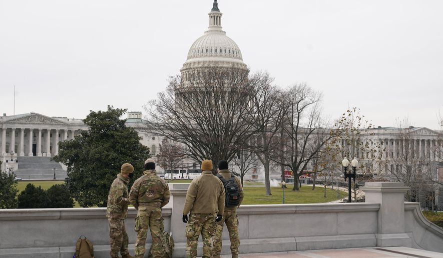 With the U.S. Capitol Building in view, members of the military stand on the steps of the Library of Congress&#39; Thomas Jefferson Building in Washington, Friday, Jan. 8, 2021, in response to supporters of President Donald Trump who stormed the Capitol. (AP Photo/Patrick Semansky)