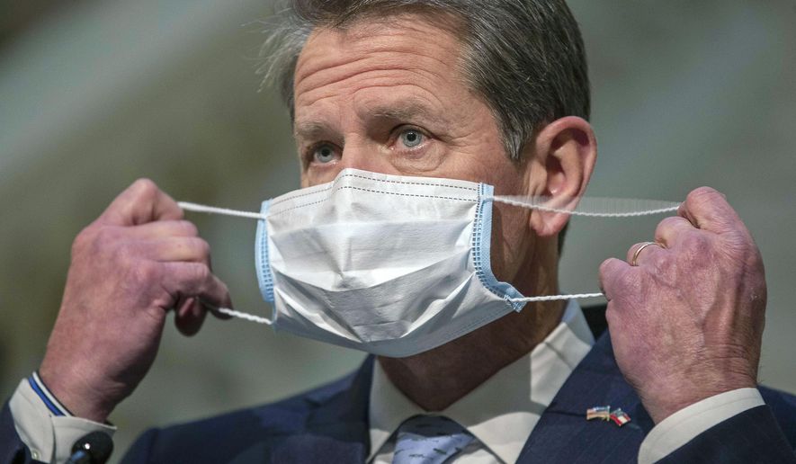 Georgia Gov. Brian Kemp adjusts his face mask during a COVID-19 update press conference at the Georgia State Capitol building in Atlanta, Tuesday, Jan. 12, 2021. (Alyssa Pointer/Atlanta Journal-Constitution via AP)