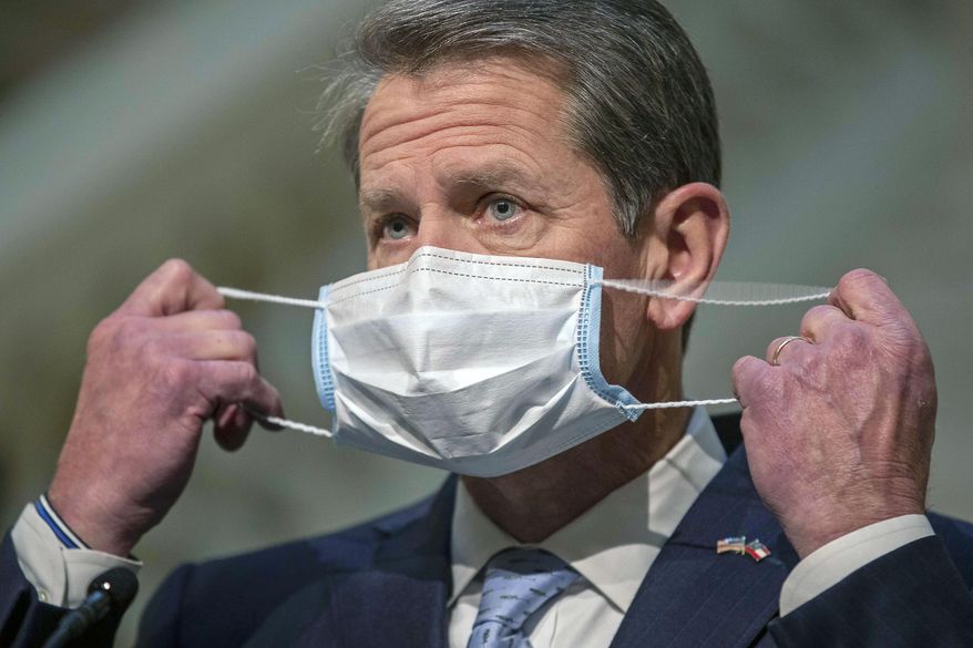Georgia Gov. Brian Kemp adjusts his face mask during a COVID-19 update press conference at the Georgia State Capitol building in Atlanta, Tuesday, Jan. 12, 2021. (Alyssa Pointer/Atlanta Journal-Constitution via AP)