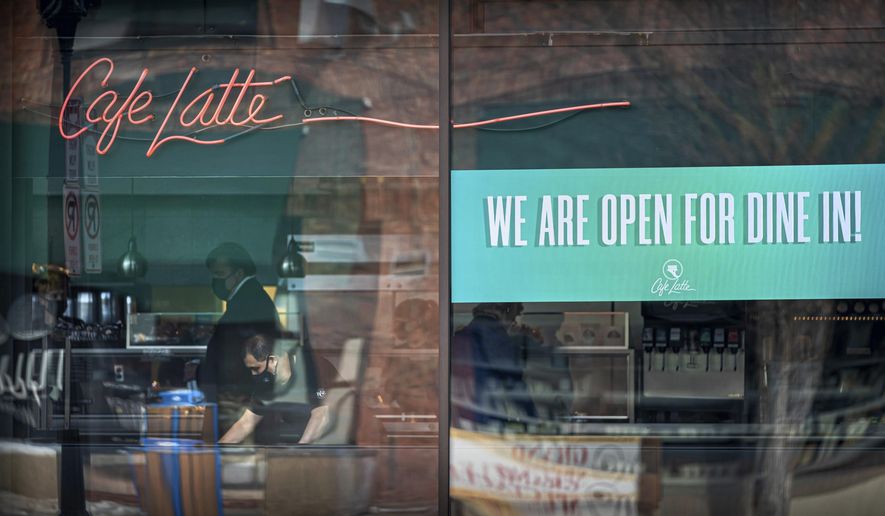 Cafe Latte on Grand Avenue, St. Paul had a sign in the window welcoming Dine In customers, on the first day of the new regulations, Monday, Jan. 11, 2021. (Glen Stubbe/Star Tribune via AP)