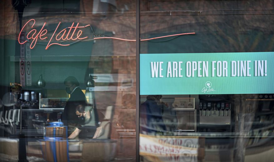 Cafe Latte on Grand Avenue, St. Paul had a sign in the window welcoming Dine In customers, on the first day of the new regulations, Monday, Jan. 11, 2021. (Glen Stubbe/Star Tribune via AP)