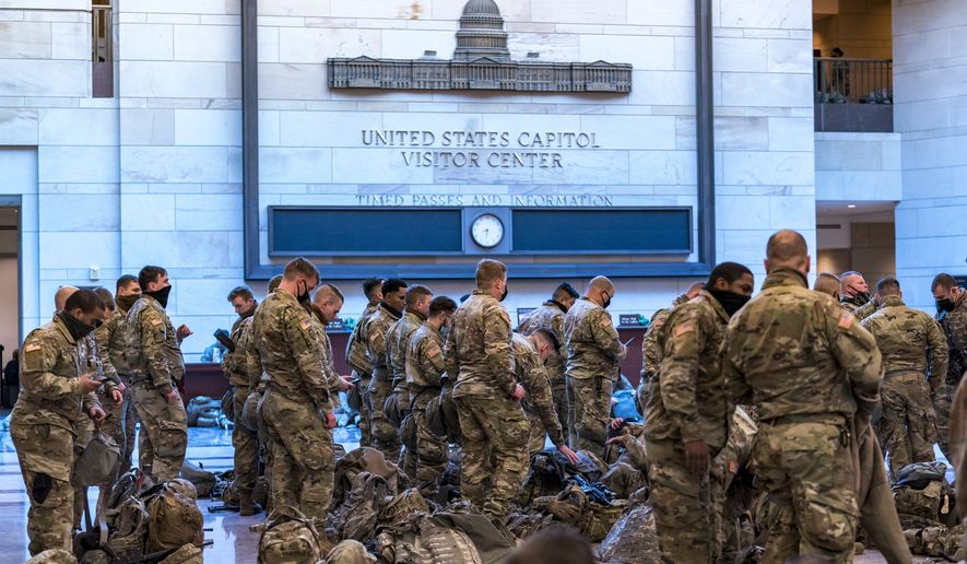 Hundreds of National Guard troops hold inside the Capitol Visitor&#39;s Center to reinforce security at the Capitol in Washington, Wednesday, Jan. 13, 2021. The House of Representatives is pursuing an article of impeachment against President Donald Trump for his role in inciting an angry mob to storm the Capitol last week. (AP Photo/J. Scott Applewhite)