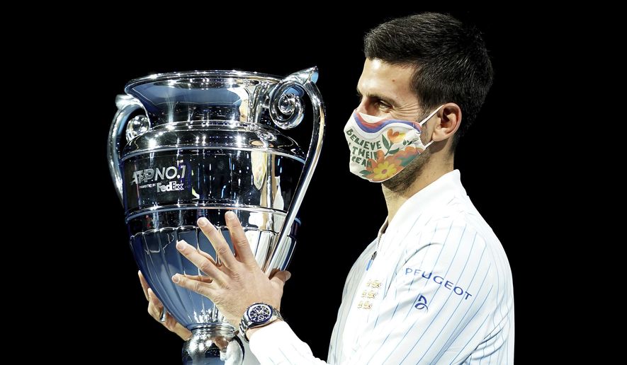 Novak Djokovic poses with his year end ATP number one trophy during day one of the ATP Finals tennis championship at The O2 Arena, London, Sunday Nov. 15, 2020. (John Walton/PA via AP)