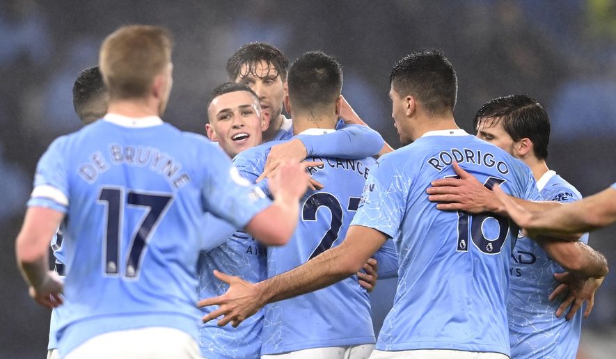 Manchester City&#39;s Phil Foden, centre, celebrates after scoring his side&#39;s opening goal during the English Premier League soccer match between Manchester City and Brighton and Hove Albion at the Etihad Stadium in Manchester, England, Wednesday, Jan. 13, 2021. (Laurence Griffiths, Pool via AP)