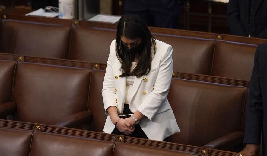 Rep. Alexandria Ocasio-Cortez, D-N.Y., bows her head during a closing prayer of a joint session of the House and Senate to confirm Electoral College votes at the Capitol, early Thursday, Jan 7, 2021, in Washington. (AP Photo/Andrew Harnik)