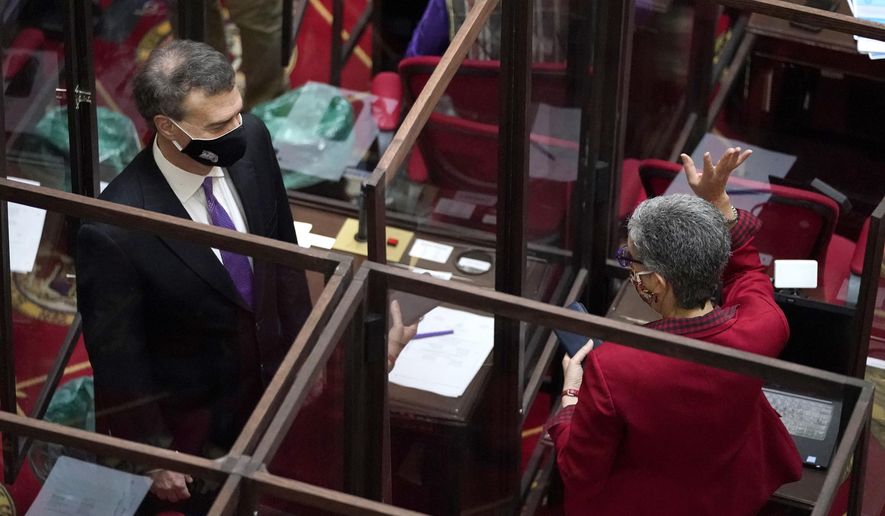 Maryland Sen. Cheryl Kagan, right, D-Montgomery County, and Sen. Brian Feldman, D-Montgomery County, are separated by plexiglass barriers while talking before the start of the state&#39;s 2021 legislative session, Wednesday, Jan. 13, 2021, in Annapolis, Md. (AP Photo/Julio Cortez)