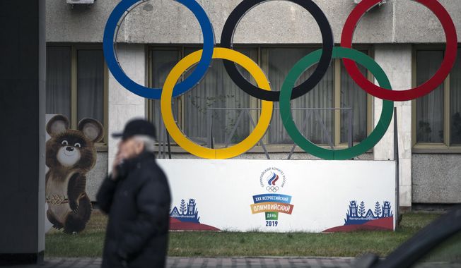 FILE - In this Nov. 28, 2019 file photo Olympic Rings and a model of Misha the Bear Cub, the mascot of the Moscow 1980 Olympic Games, left, are seen in the yard of Russian Olympic Committee building in Moscow, Russia. In the report detailing its decision to shorten Russia&#x27;s ban from the Olympics, the highest court in sports blasted that country&#x27;s leaders for engaging in “a cover up of the cover-up” in a desperate attempt to deny their culpability, but reduced the punishment nonetheless, Wednesday, Jan. 13, 2021. (AP Photo/Pavel Golovkin, file)