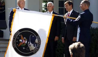 FILE _ In this Aug. 29, 2019 file photo, President Donald Trump watches with Vice President Mike Pence and Defense Secretary Mark Esper as the flag for U.S. space Command is unfurled as Trump announces the establishment of the U.S. Space Command in the Rose Garden of the White House in Washington.   The U.S. Air Force is expected to announce Huntsville, Ala. as the location for the U.S. Space Command headquarters, according to  Gov. Kay Ivey.   The governor said she was informed of the decision Wednesday, Jan. 13, 2021.   (AP Photo/Carolyn Kaster, File)