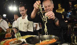 FILE - Chef Wolfgang Puck right, and his son Byron make a pasta dish at the Governors Ball Press Preview for the 92nd Academy Awards in Los Angeles on Jan. 31, 2020. A new four-part documentary series, “The Event,” shows the intense planning and details that go into high-profile catering. The series premieres on HBO Max on Jan. 14.  (AP Photo/Chris Pizzello, File)