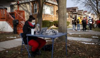 Meghan Hayes, who teaches at John Hay Community Academy, teaches her class outside Chicago Public Schools Board President Miguel del Valle&#x27;s home, Wednesday morning, Jan. 13, 2021, in Chicago. Educators who were teaching remotely joined some teachers who were locked out of their remote teaching accounts because of their refusal to teach in-person due to COVID-19 safety concerns. (Pat Nabong/Chicago Sun-Times via AP)