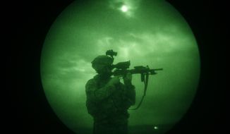 In this Monday, April 21, 2008 file photo, a U.S soldier looks through the scope of his weapon during a night patrol in Mandozai, in Khost province, Afghanistan, seen through night vision equipment. About 400,000 veterans had a PTSD diagnosis in 2013, according to the Veterans Affairs health system. (AP Photo/Rafiq Maqbool)